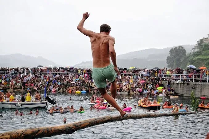 La cucaña en el puerto durante las fiestas de Lastres